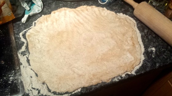 Als nächsten Schritt rollt man den Teig mit einem Nudelholz auf einer mit Mehl bestreuten Fläche aus.